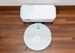 robo-aspirador-w4000-branco-com-uma-visao-de-cima-em-um-piso-de-madeira-marrom-com-a-base-de-limpeza-branca-vista-de-cima-7899831332656-7899831332670